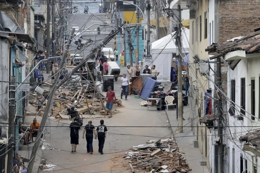 Personas caminan frente a edificaciones afectadas por el terremoto de magnitud 7,4, en Pereira