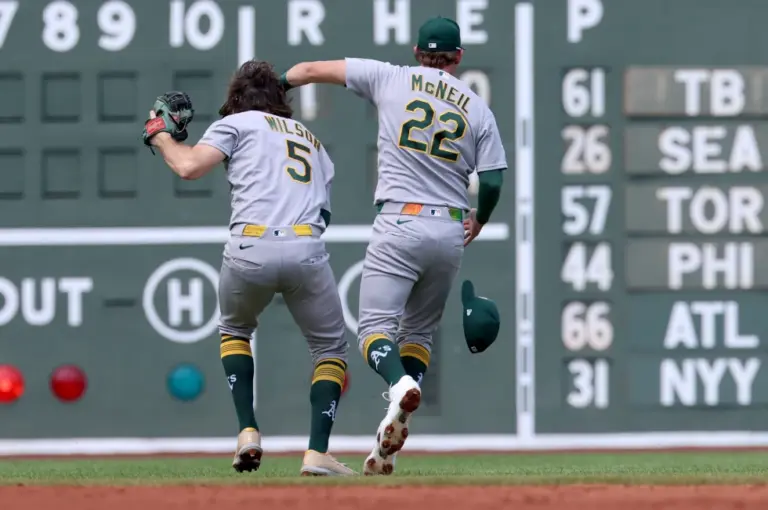 En la foto, Jacob Wilson (5), de los Atléticos, atrapa un elevado mientras choca con su compañero Jeff McNeil (22) durante la segunda entrada del juego de béisbol de Grandes Ligas frente a los Medias Rojas de Boston, el domingo 9 de agosto de 2026, en Boston.