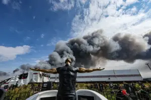 En la foto, una escultura funeraria en un cementerio mientras el humo se eleva sobre una instalación de Wildberries (al fondo) tras un ataque con drones ucranianos en el parque industrial de Koledino, cerca de Podolsk (región de Moscú, Rusia), el 16 de agosto de 2026
