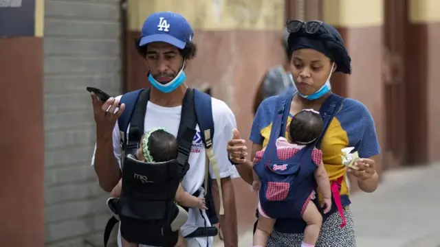 En la foto, imagen de archivo de una pareja caminando con sus bebés en La Habana