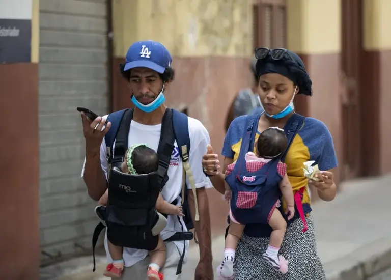 En la foto, imagen de archivo de una pareja caminando con sus bebés en La Habana