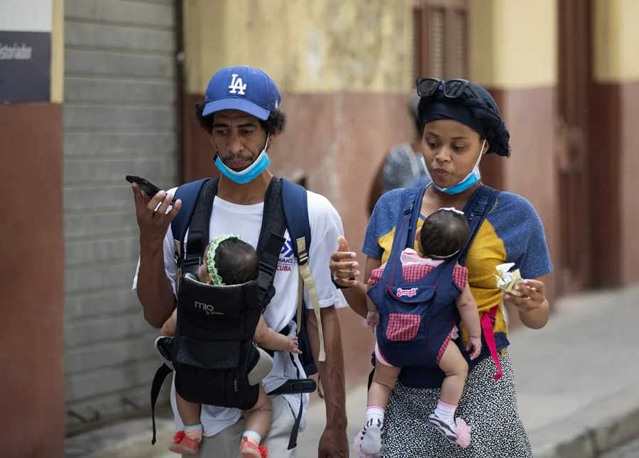 En la foto, imagen de archivo de una pareja caminando con sus bebés en La Habana