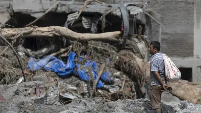 En la foto, Un superviviente de las inundaciones regresa a su hogar este jueves tras una crecida repentina en la aldea de Devighat, distrito de Nuwakot (Nepal)