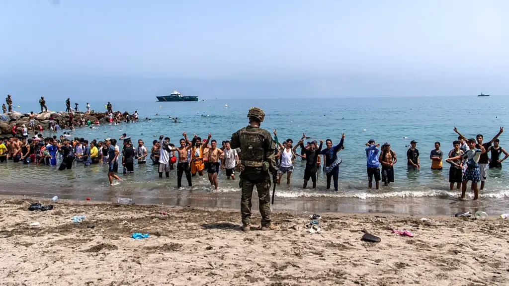 Ceuta, una crisis migratoria que puso a prueba al Estado español 2 Crisis migratoria en Ceuta: migrantes en una playa frente a la frontera con Marruecos