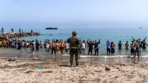 Crisis migratoria en Ceuta: migrantes en una playa frente a la frontera con Marruecos