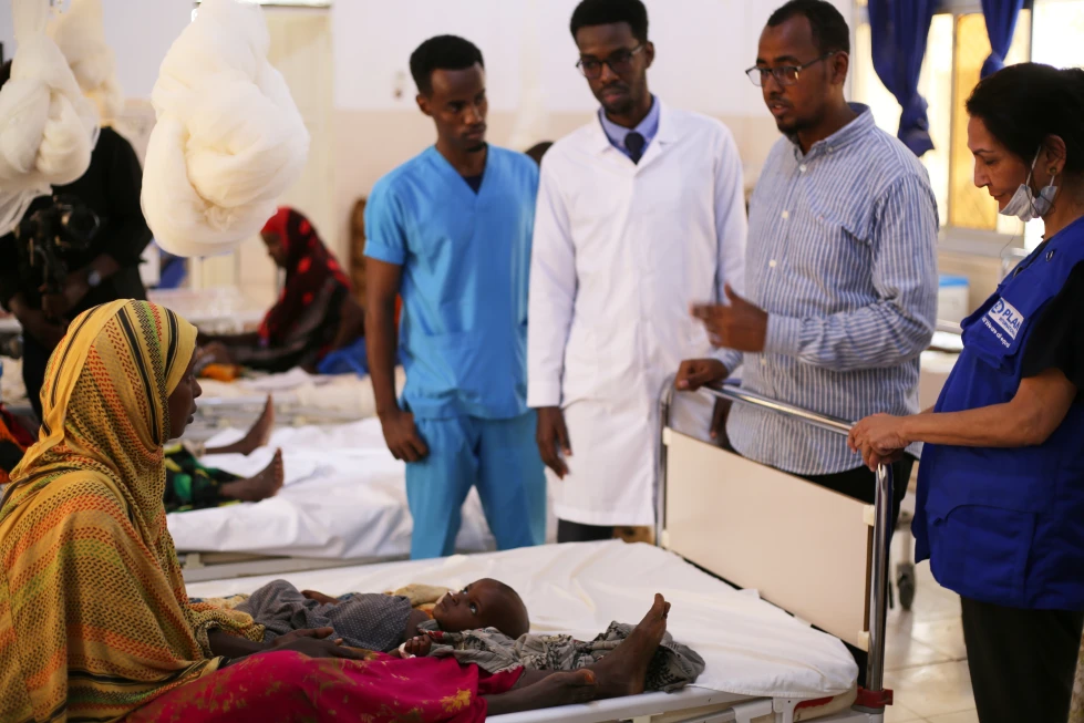 Miles huyen de la sequía prolongada en Somalia mientras el hambre se agrava y la ayuda se reduce 4 En la foto, Trabajadores de la salud hablan con una mujer con un hijo desnutrido en el Hospital Infantil en Baidoa, Somalia, el 4 de agosto de 2026