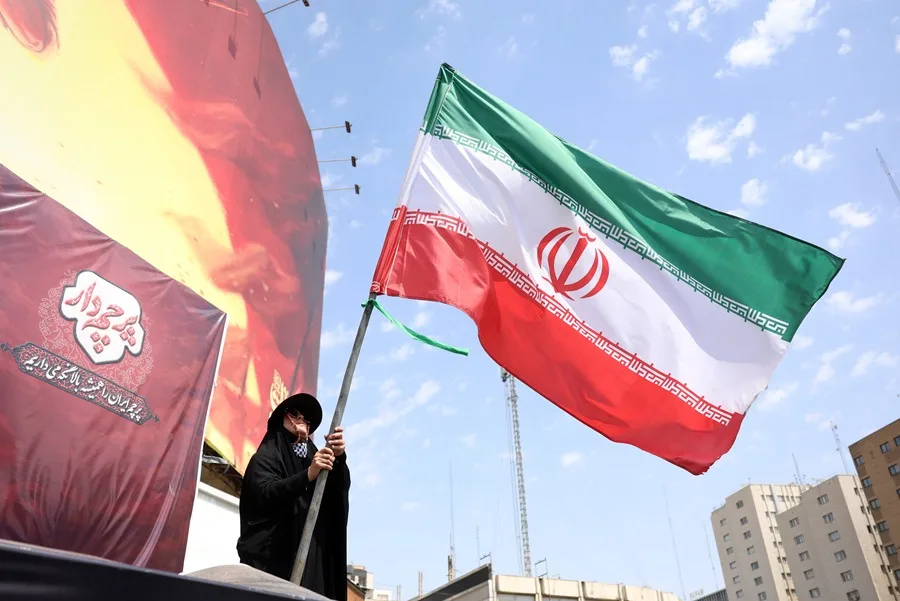 En la foto, una mujer sosteniendo la bandera de Irán, en Teherán