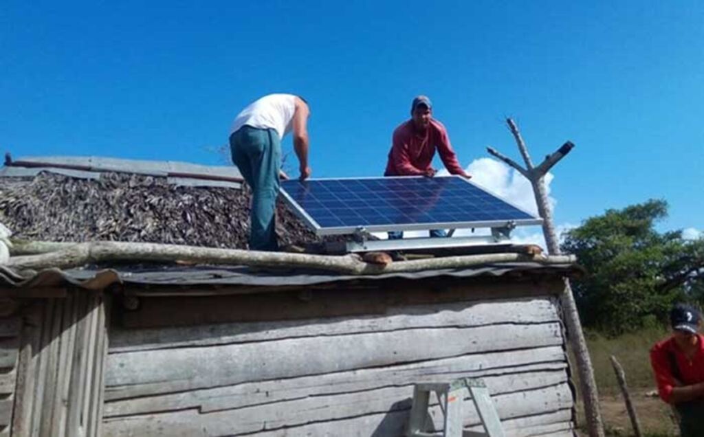 En la foto, instalan un panel solar en una casa de campo en Cuba