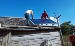 En la foto, instalan un panel solar en una casa de campo en Cuba