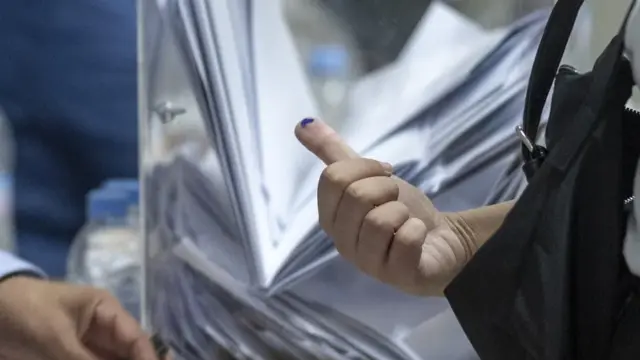 En la foto, Una mujer tiene el dedo marcado con tinta tras emitir su voto en un colegio electoral de Rabat (Marruecos)