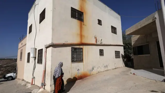 En la foto, Una mujer palestina caminaba frente a su casa en la aldea de Jalud, en Cisjordania, el pasado16 de septiembre