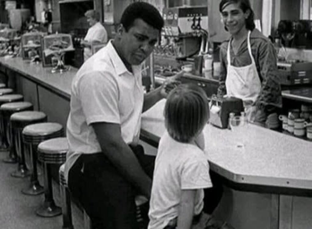 En la foto, Muhammad Ali con un niño