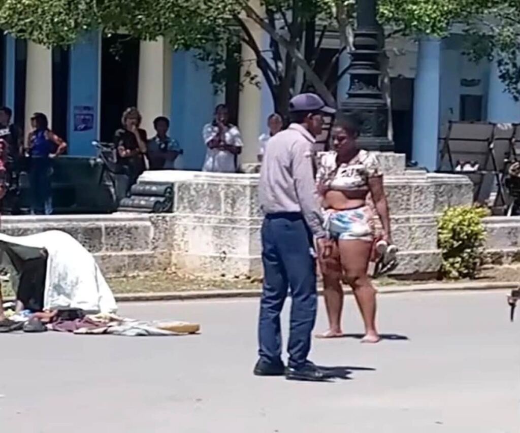 En la foto, un policía intenta convencer a una mujer para que abandone un bloqueo en la calle Prado
