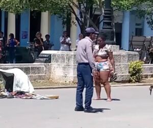 En la foto, un policía intenta convencer a una mujer para que abandone un bloqueo en la calle Prado