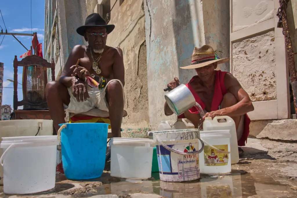 En la foto, Oscar Joaquín López, a la izquierda, y su compañero de piso Wilfredo Cisneros Duarte recogen agua de una tubería pública en La Habana, Cuba, el lunes 7 de septiembre de 2026