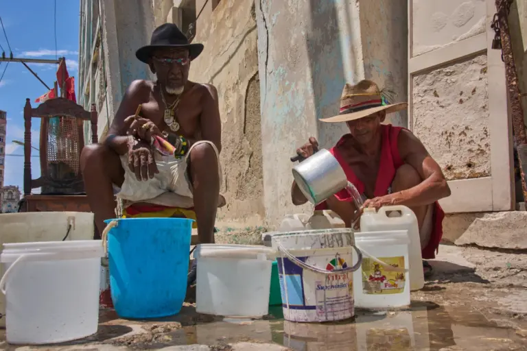 En la foto, Oscar Joaquín López, a la izquierda, y su compañero de piso Wilfredo Cisneros Duarte recogen agua de una tubería pública en La Habana, Cuba, el lunes 7 de septiembre de 2026