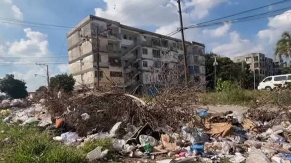 En la foto, un basurero ante un edificio en Cuba