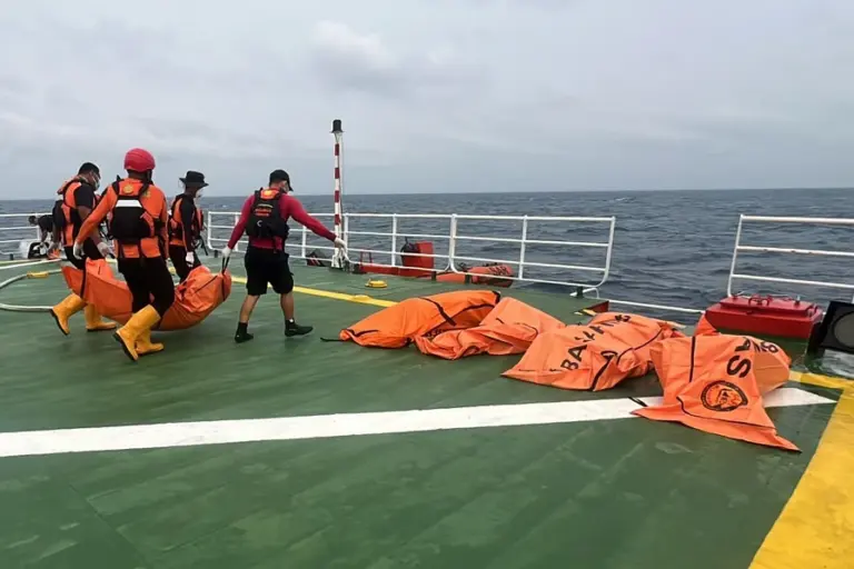En la foto, rescatistas trasladan el cuerpo de una víctima del naufragio de un transbordador enn un barco de la agencia, en el mar de Java, Indonesia