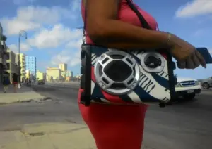 En la foto, una mujer escucha música alta al lado del malecón