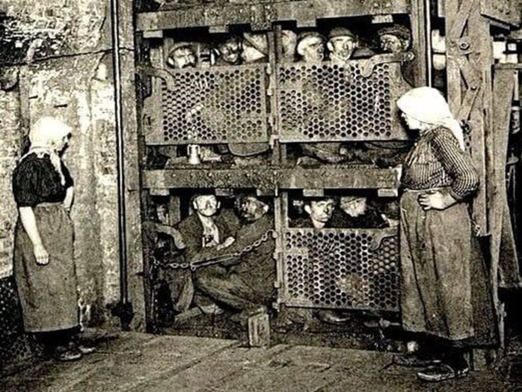 En la foto, mineros dentro de una jaula para bajar a la mina