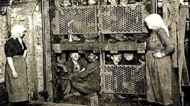 En la foto, mineros dentro de una jaula para bajar a la mina