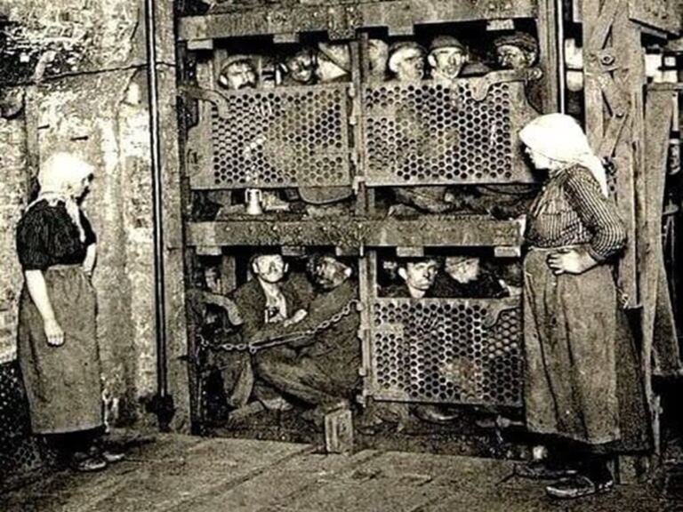 En la foto, mineros dentro de una jaula para bajar a la mina