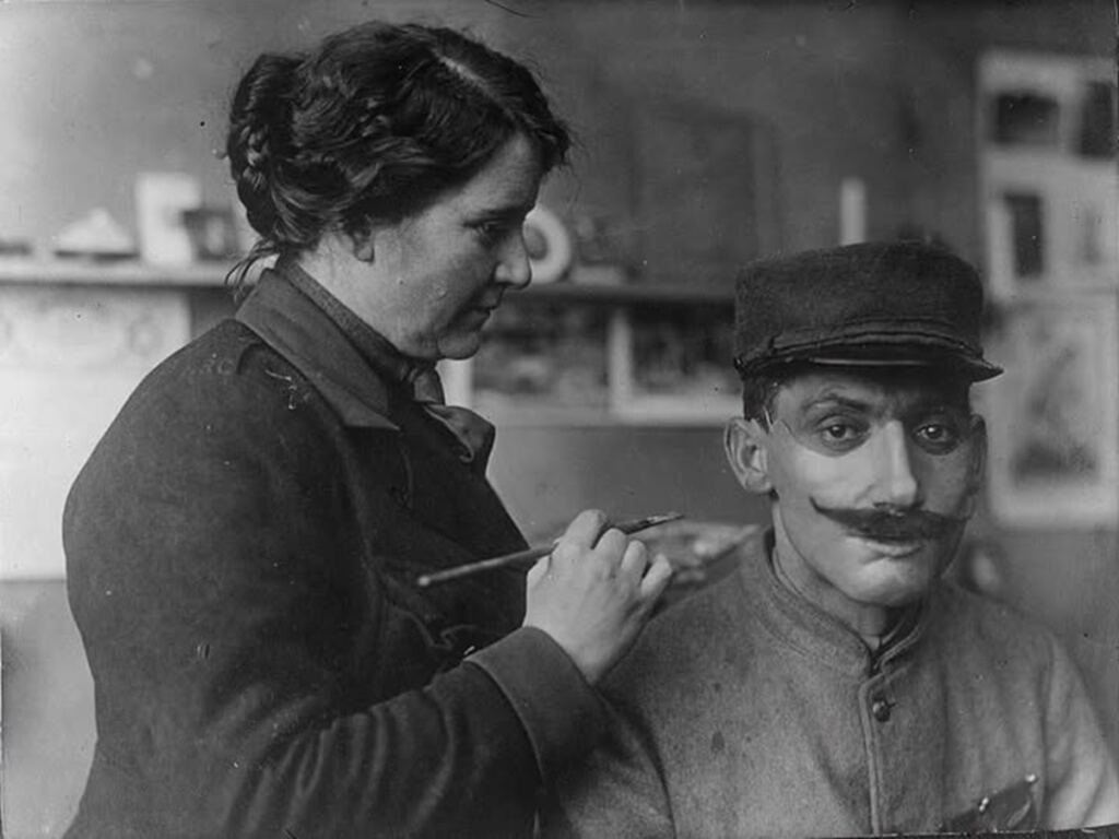 En la foto, Anna Coleman Ladd pinta una máscara en el rostro de un soldado
