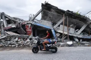 En la foto, una mujer pasando frente a un edificio destruido por el terremoto del 10 de agosto, en Quibdó (Colombia)