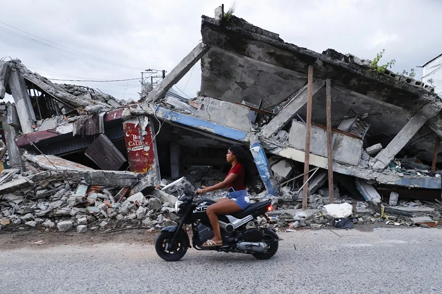 En la foto, una mujer pasando frente a un edificio destruido por el terremoto del 10 de agosto, en Quibdó (Colombia)