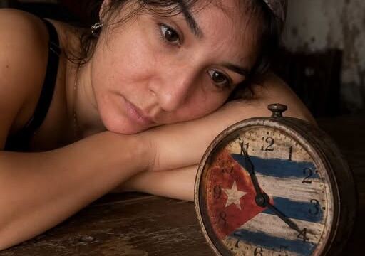En la foto, una mujer recostada ante un reloj con la bandera cubana en su esfera