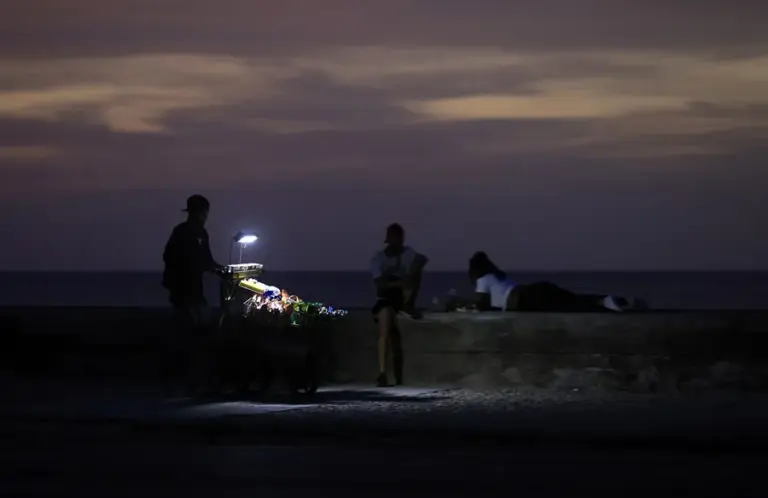 En la foto, un vendedor durante un apagón, en La Habana