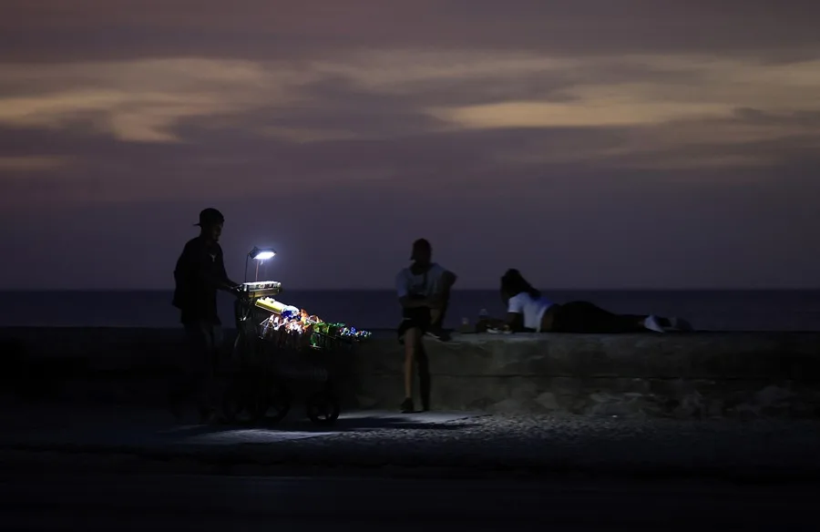 En la foto, un vendedor durante un apagón, en La Habana