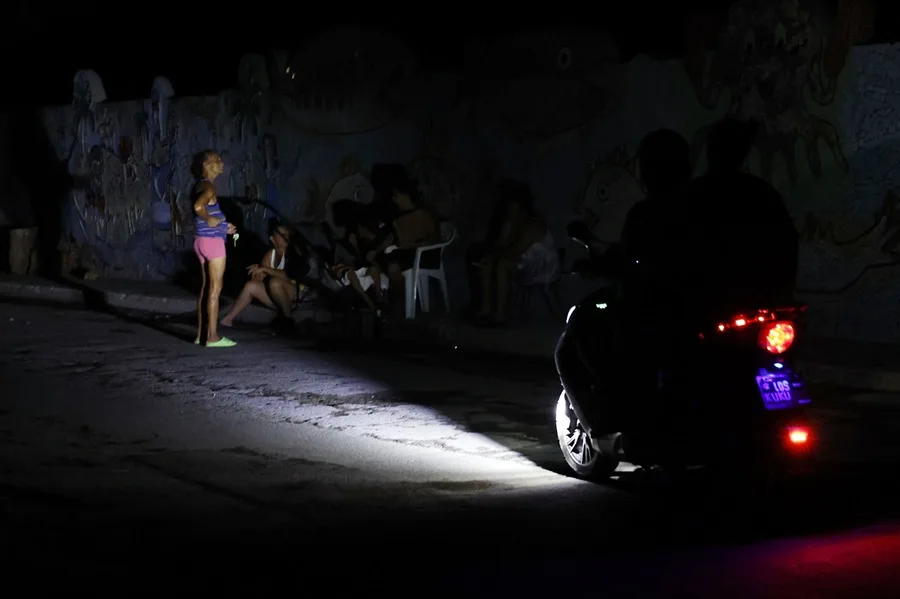 En la foto, personas en una calle durante un apagón, en La Habana
