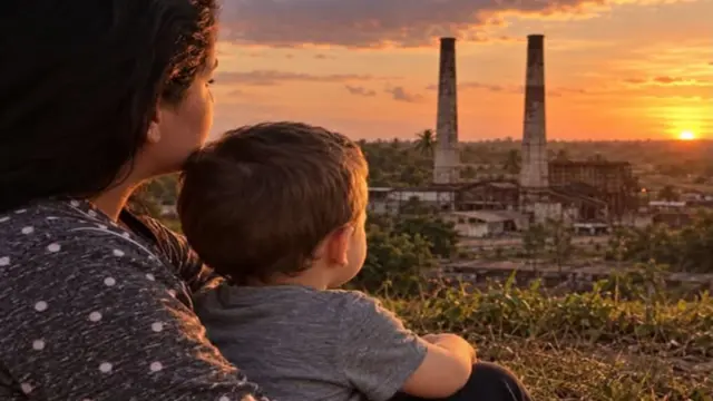 La Patria que vino conmigo 1 En la foto, una mujer con un niño mirando a la destruida Cuba