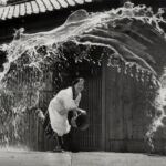 En la foto, una mujer japonés lanza agua a la calle