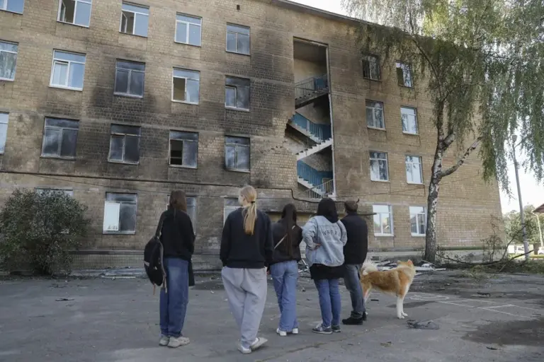 En la foto, Unos niños de la zona permanecen cerca del lugar donde impactó un dron ruso contra un edificio escolar en una zona residencial de Kiev