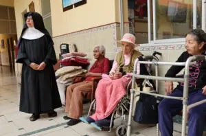 En la foto, Una religiosa camina junto a adultos mayores en la casa asilo de las Hermanitas de los Ancianos Desamparados, en el Callao (Perú)