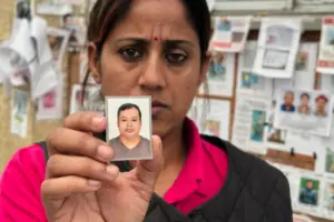 En la foto, Usha Khatri muestra una foto de su esposo, Indra Bahadur, desaparecido desde las inundaciones del mes pasado en el exterior del hospital universitario Tribhuvan, en Katmandú