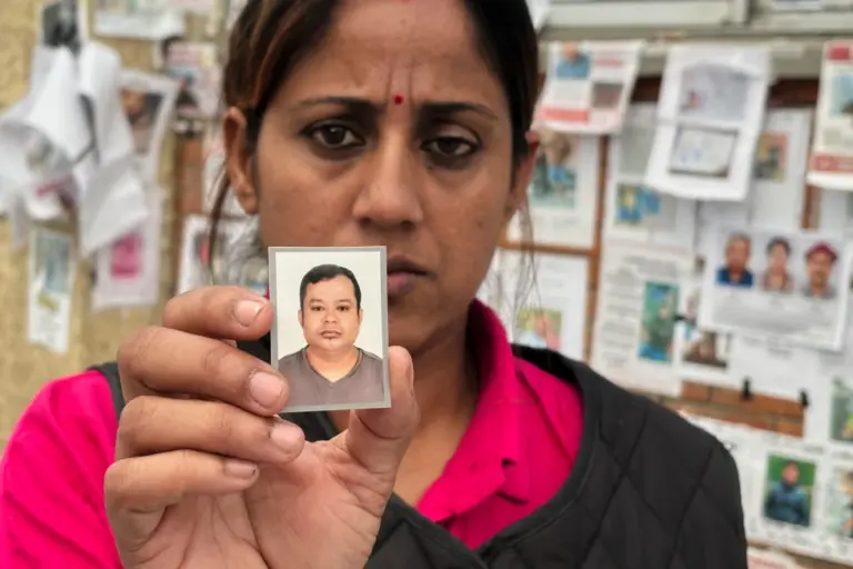 En la foto, Usha Khatri muestra una foto de su esposo, Indra Bahadur, desaparecido desde las inundaciones del mes pasado en el exterior del hospital universitario Tribhuvan, en Katmandú