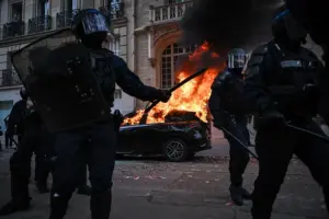 En la foto, Un automóvil arde mientras se producen enfrentamientos con la policía antidisturbios
