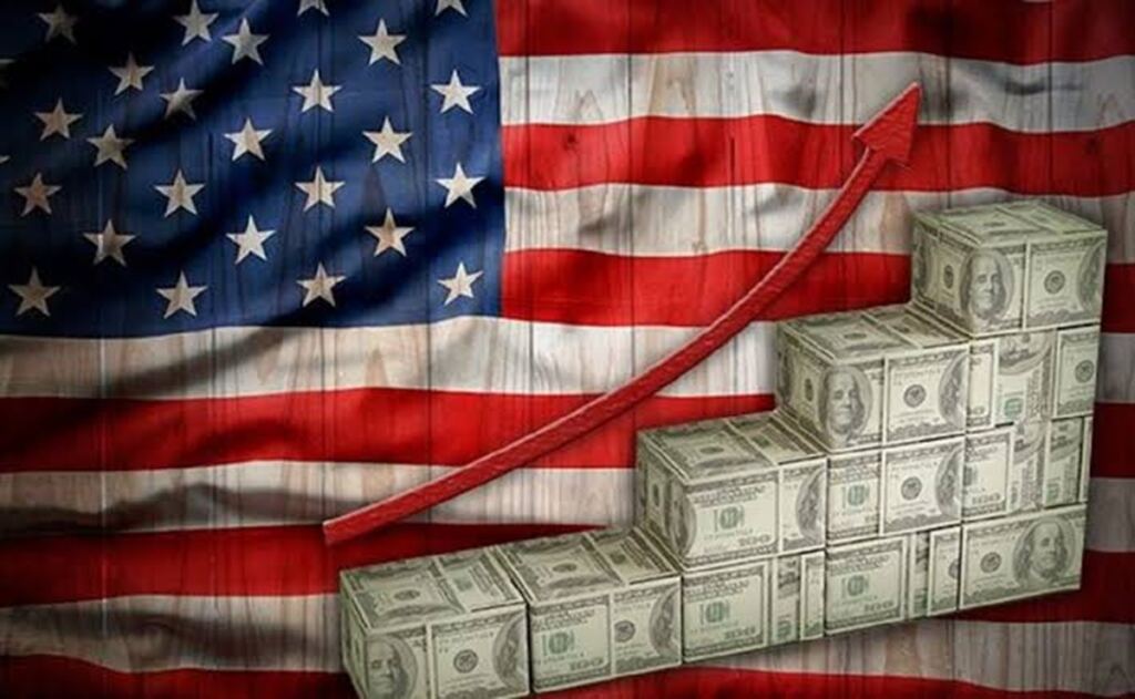 EEUU: La economía de EE.UU. crece 3,4% en el tercer trimestre, pero la inflación no cede 3 En la foto, una bandera de EEUU y paquetes de billes de dólares