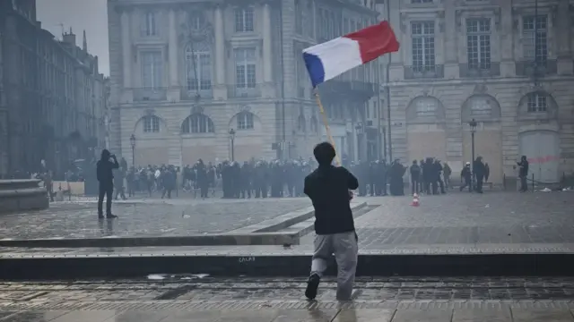 Francia afronta una nueva semana de movilizaciones sociales con caceroladas y protestas 1 En la foto, una persona con una bandera francesa durante una movilización, en Burdeos