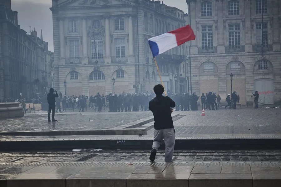 En la foto, una persona con una bandera francesa durante una movilización, en Burdeos