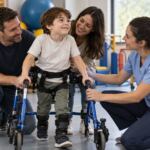 Niño usando apoyo de movilidad con sus padres y una fisioterapeuta neuromuscular